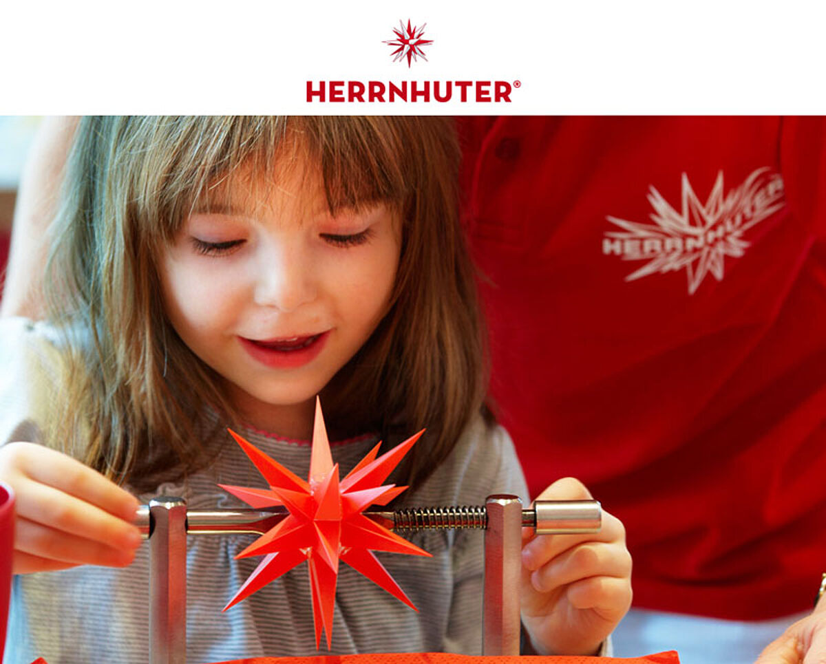 Kind, welches sich am Bau eines kleinen Kunststoffsterns probiert