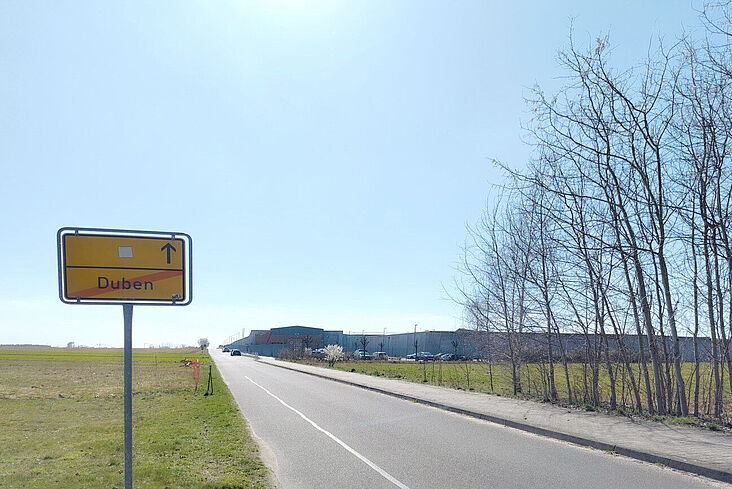 Ortsausgangsschild von Duben; im Hintergrund die JVA