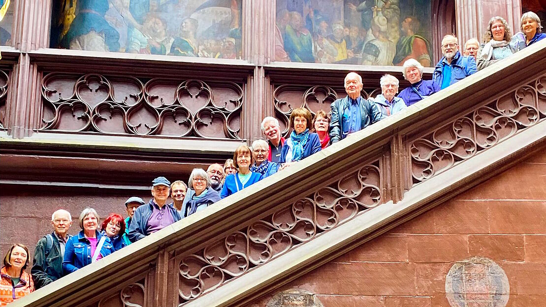 Gruppenbild der Teilnehmer und Teilnehmerinnen, welche auf einer großen Steintreppe verteilt stehen und über die Brüstung schauen