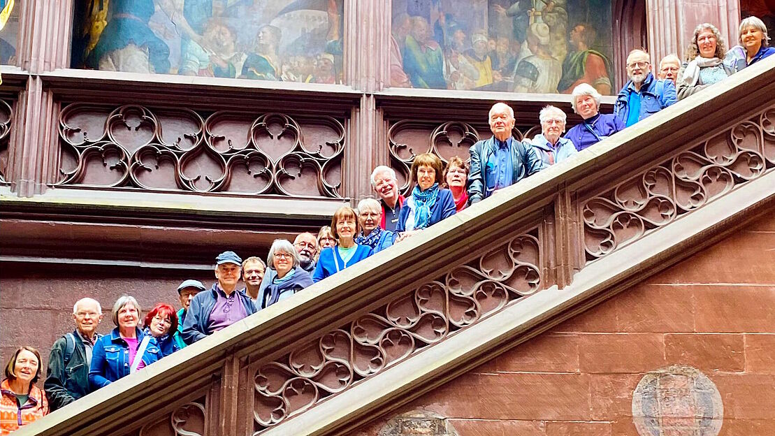 Gruppenbild der Teilnehmer und Teilnehmerinnen, welche auf einer großen Steintreppe verteilt stehen und über die Brüstung schauen