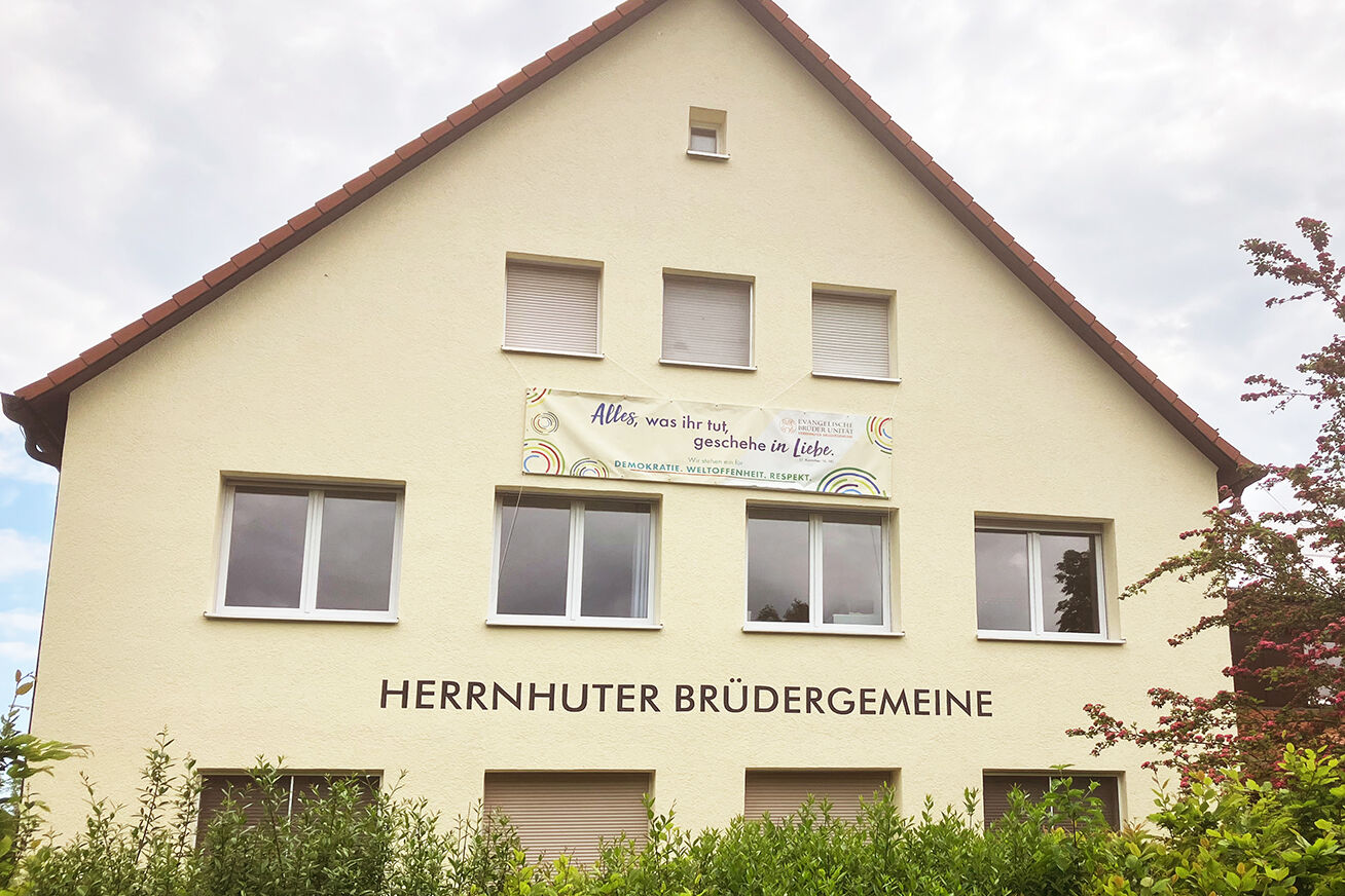 Banner mit Aufschrift "Alles was ihr tut, geschehe in Liebe" am Unitätshaus in Bad Boll