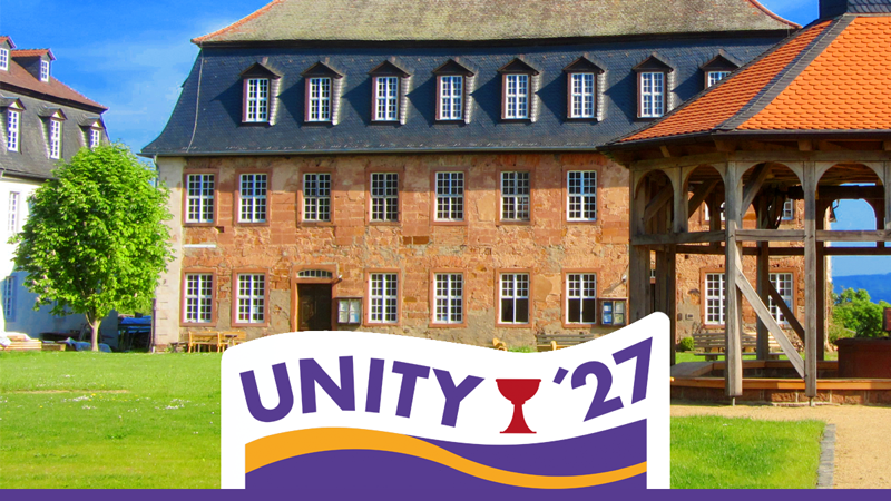 Link zu Veranstaltung – Bild der Lichtenburg in Herrnhaag mit Brunnenhaus im Vordergrund; davor das Logo Unity '27